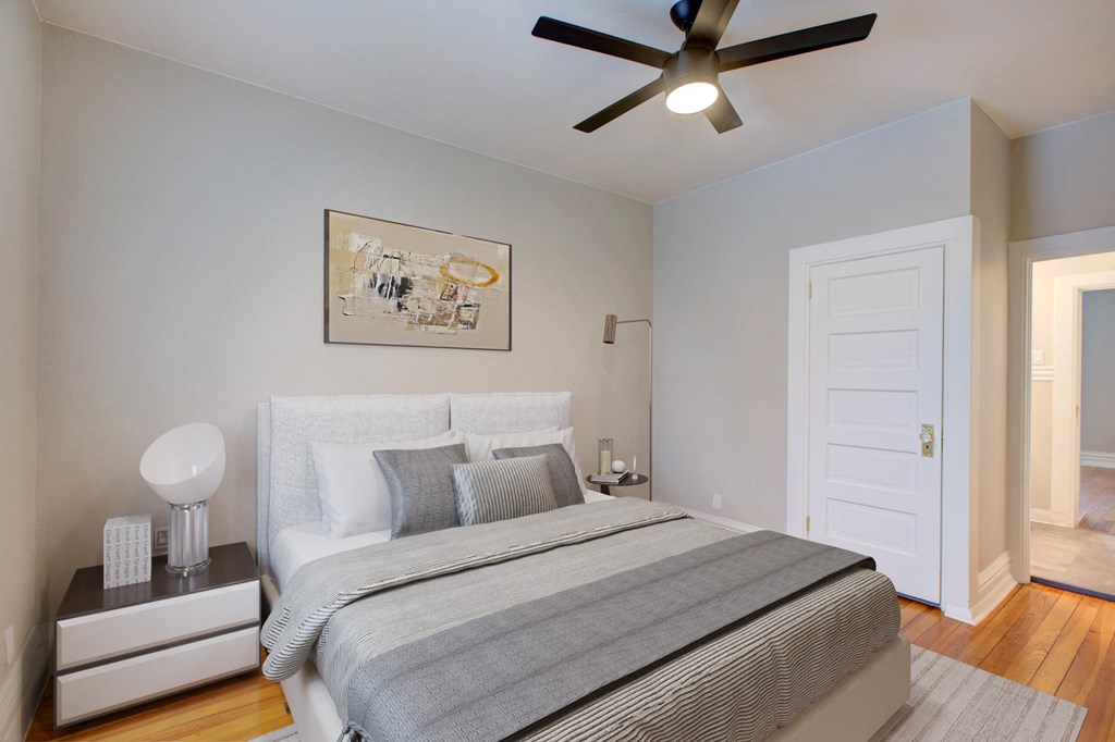 a bedroom with a bed and a ceiling fan