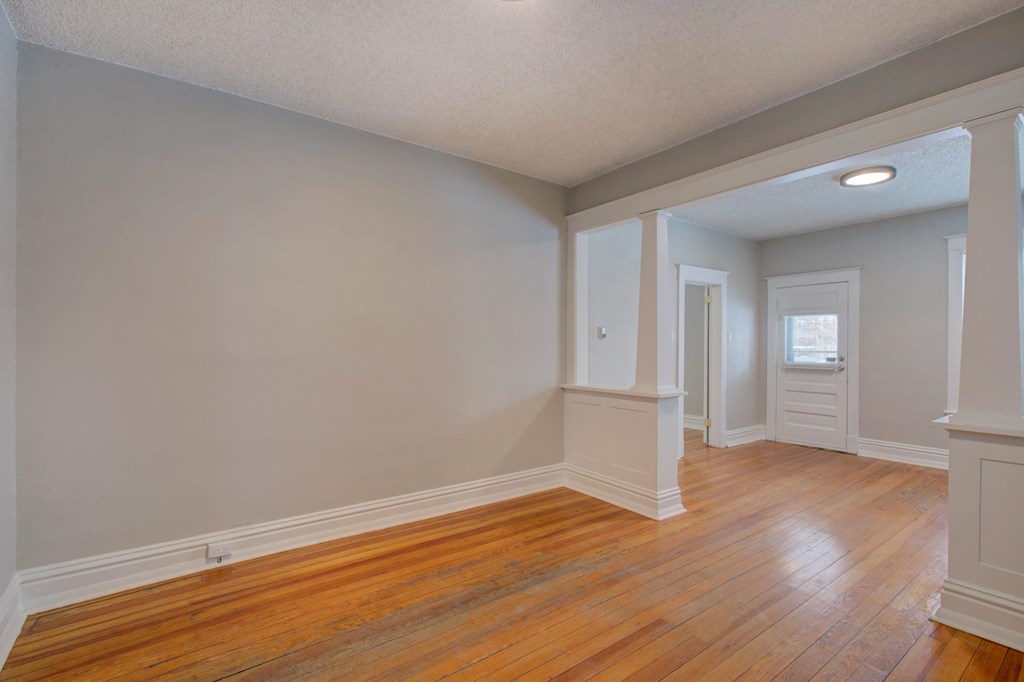 the living room and dining room of an empty house