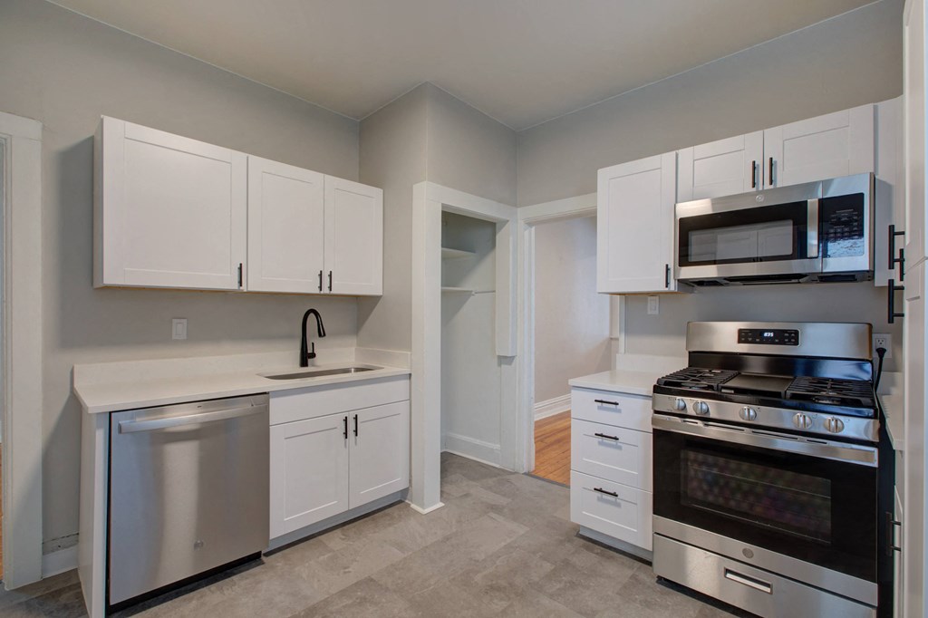 a kitchen with stainless steel appliances and white cabinets