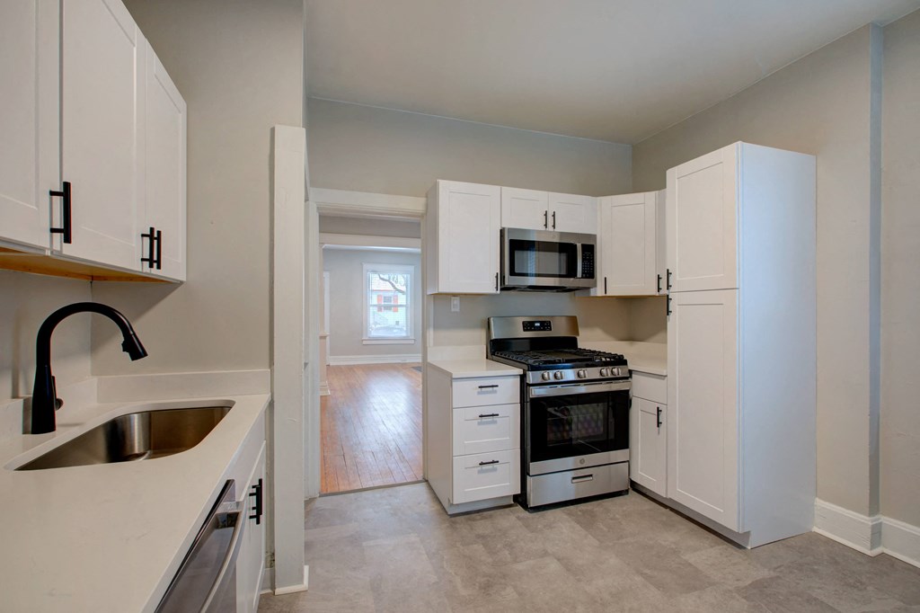 a kitchen with white cabinets and stainless steel appliances