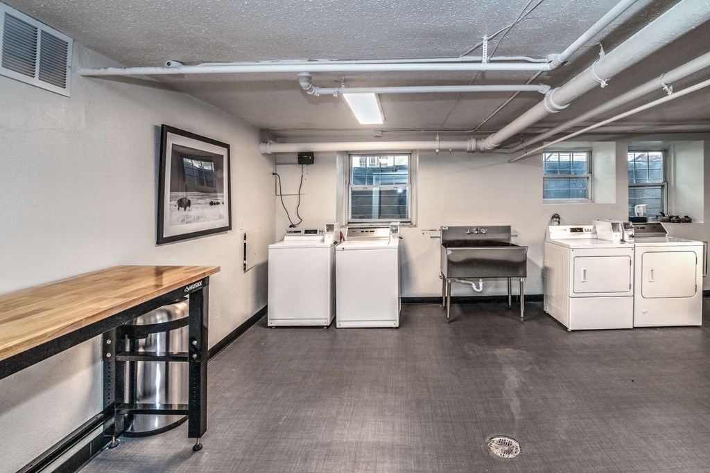 a laundry room with washing machines and a table with a wooden table top