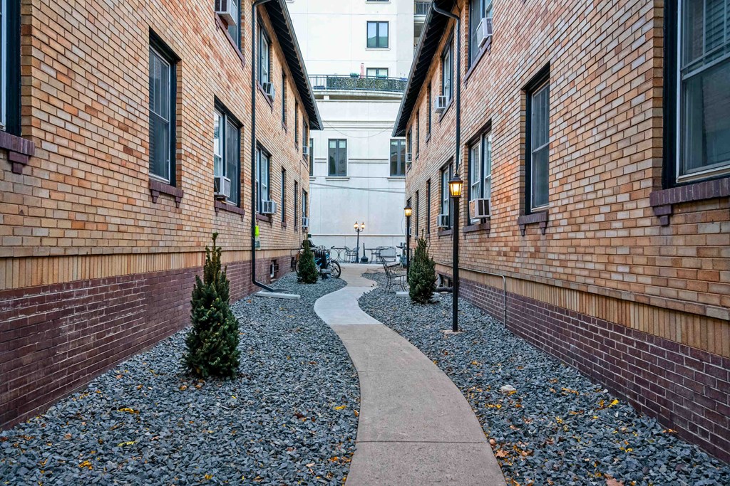 a courtyard with a stone path and a brick building