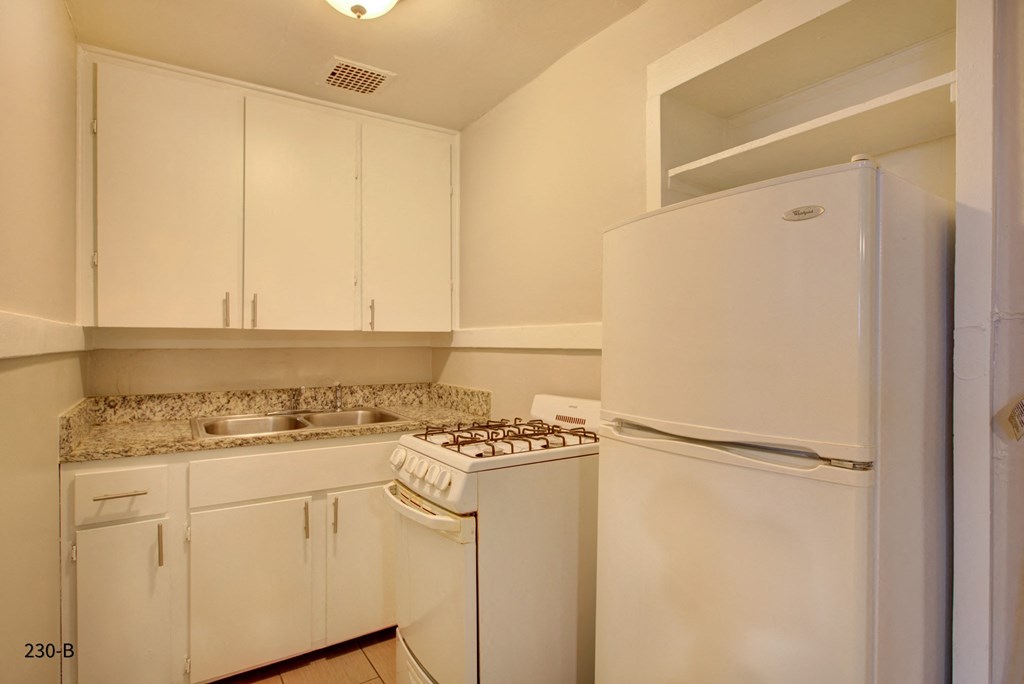a kitchen with white appliances and white cabinets