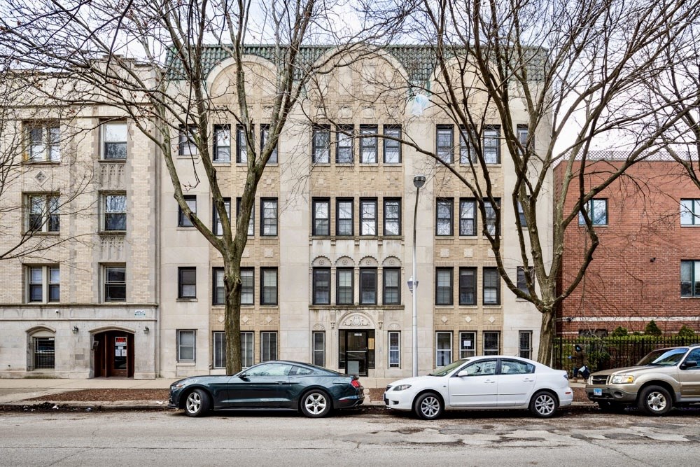 the exterior of a building with cars parked in front of it