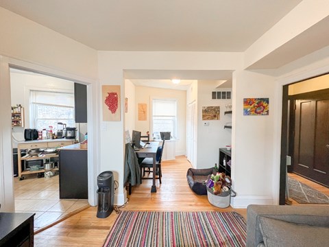 A living room with a couch and a striped rug.