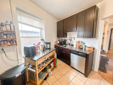 A kitchen with a black counter top and wooden cabinets.
