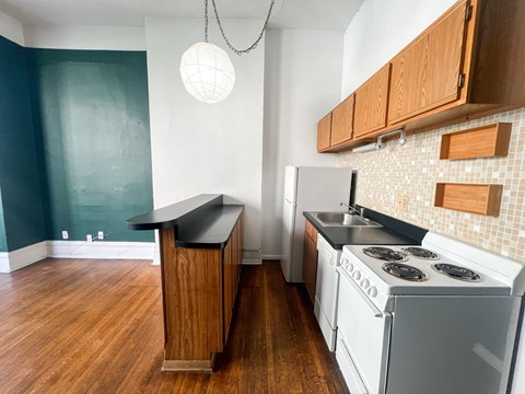 A kitchen with a white stove and wooden cabinets.