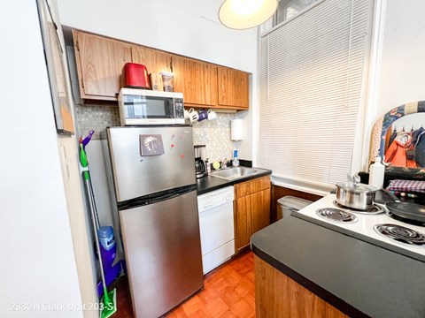 A kitchen with a stove, refrigerator, and dishwasher.
