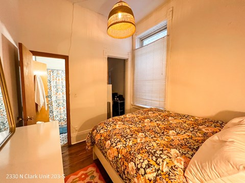 A bedroom with a bed covered in a floral print bedspread.