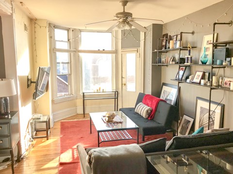 A living room with a red carpet and a glass coffee table.