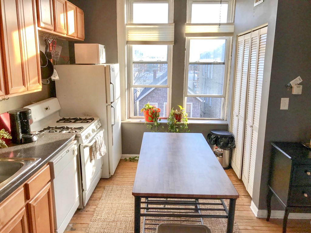 A kitchen with a table and chairs in front of a window.