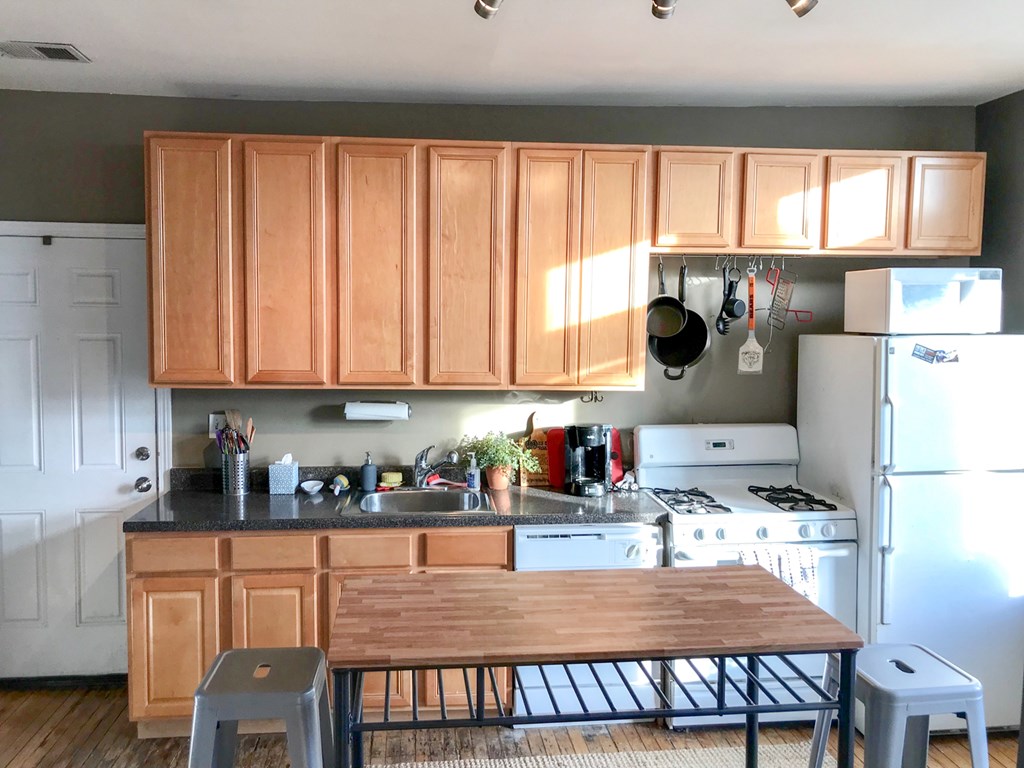 A kitchen with wooden cabinets and a black stove.