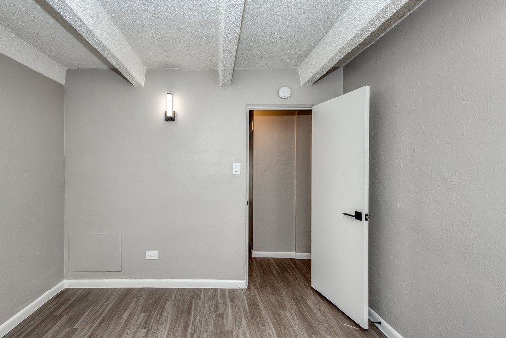 the living room of an empty apartment with a door to the hallway
