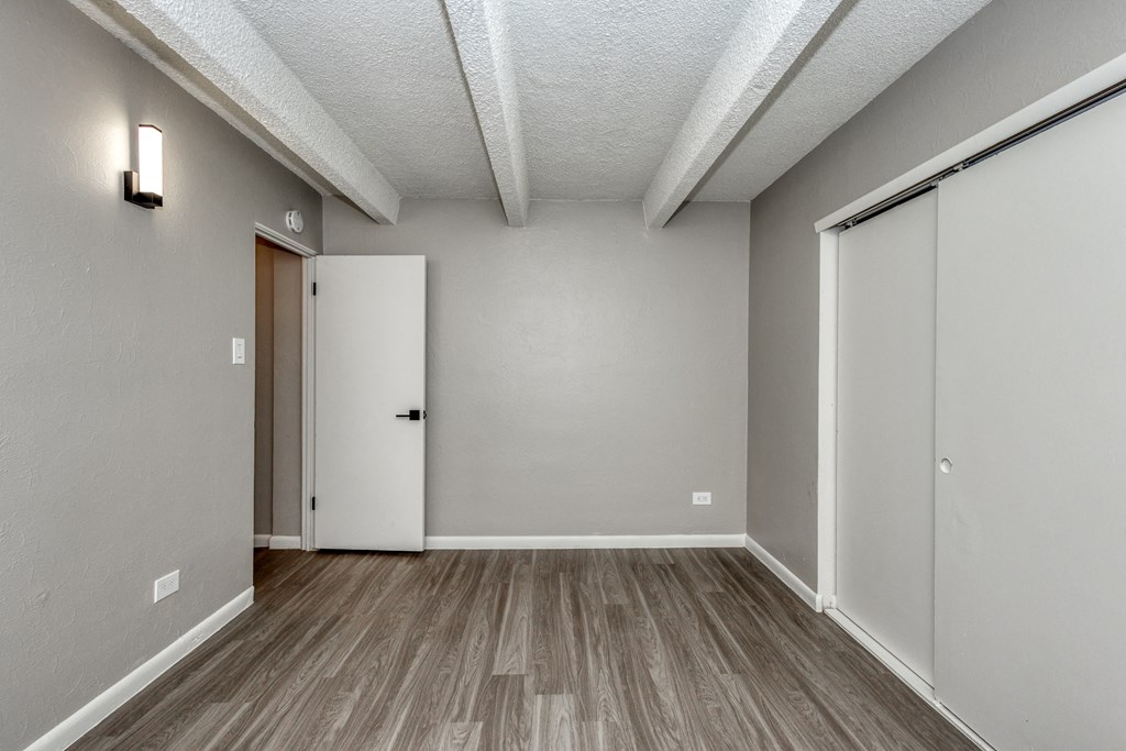the living room of an empty apartment with a door to the hallway
