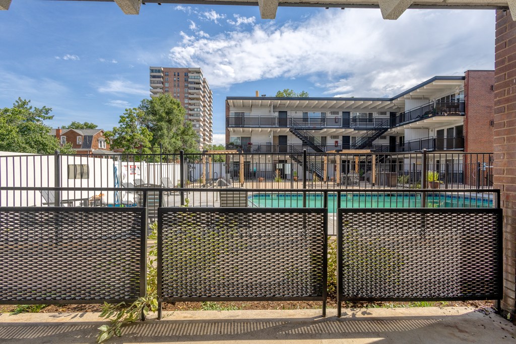the courtyard of a building with a pool and a fence