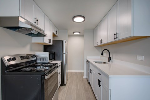 A modern kitchen with a black stove top oven and a black refrigerator.