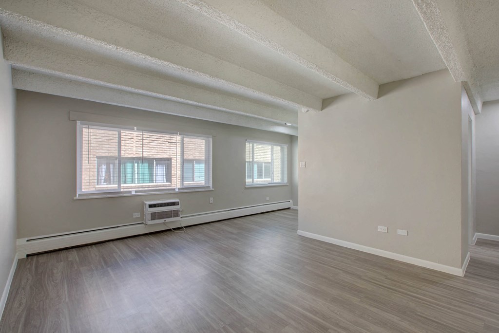 the living room and dining room of an empty apartment