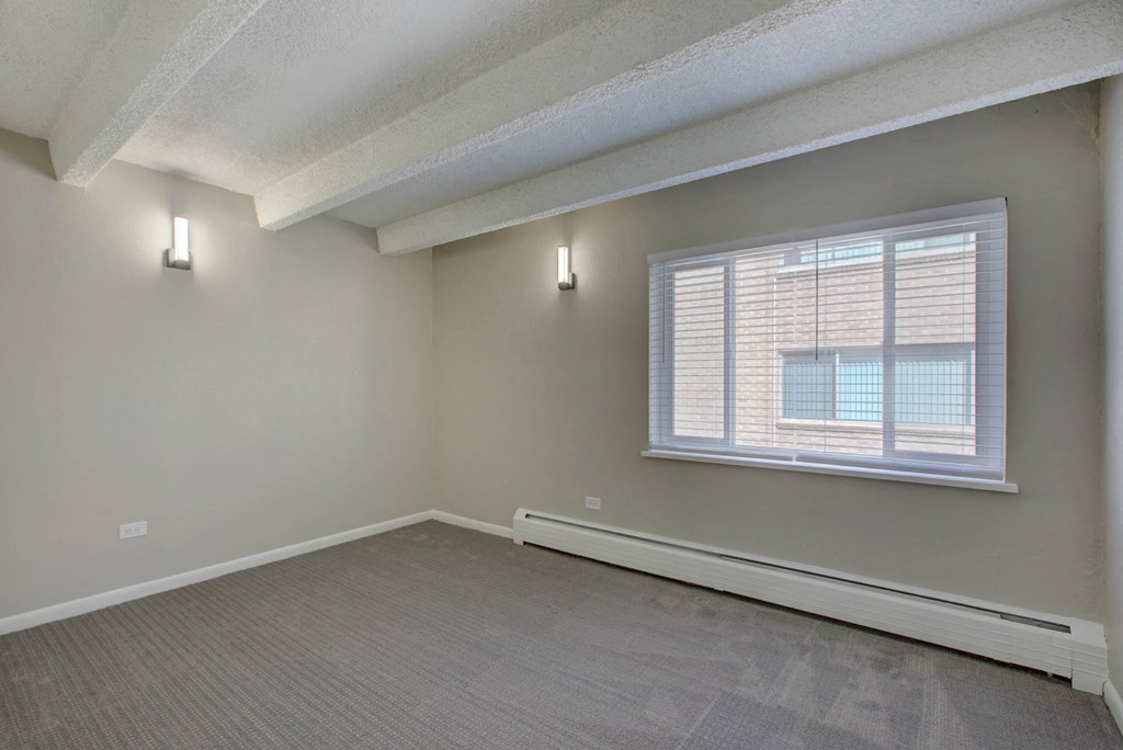 the living room of an empty apartment with a large window