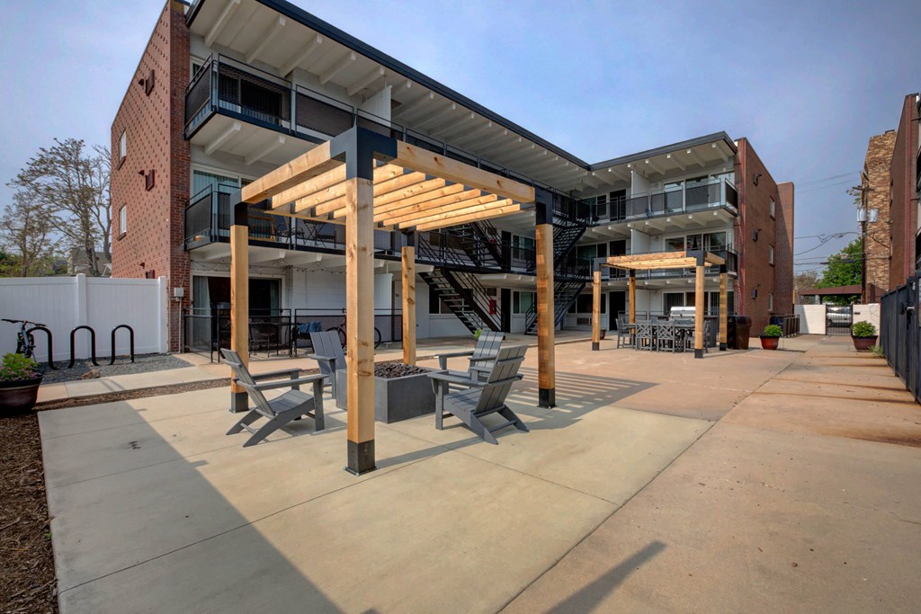 a patio with benches and a building in the background