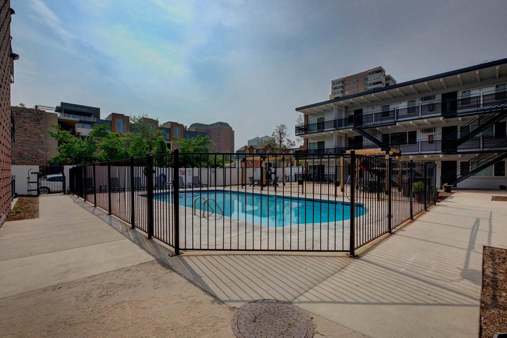the pool is protected by a fence in front of an apartment building