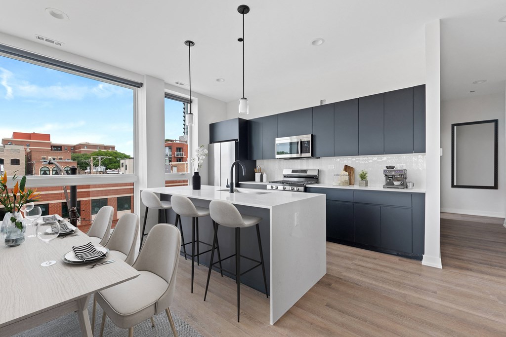 a kitchen and dining area with a large window and a city view