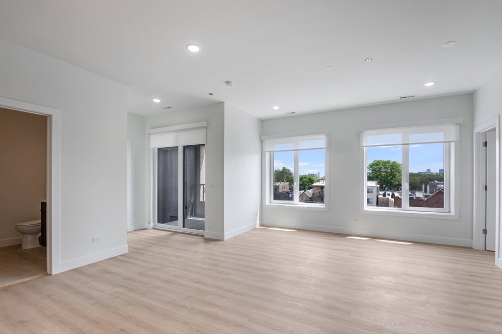 A large, empty room with wooden floors and white walls.