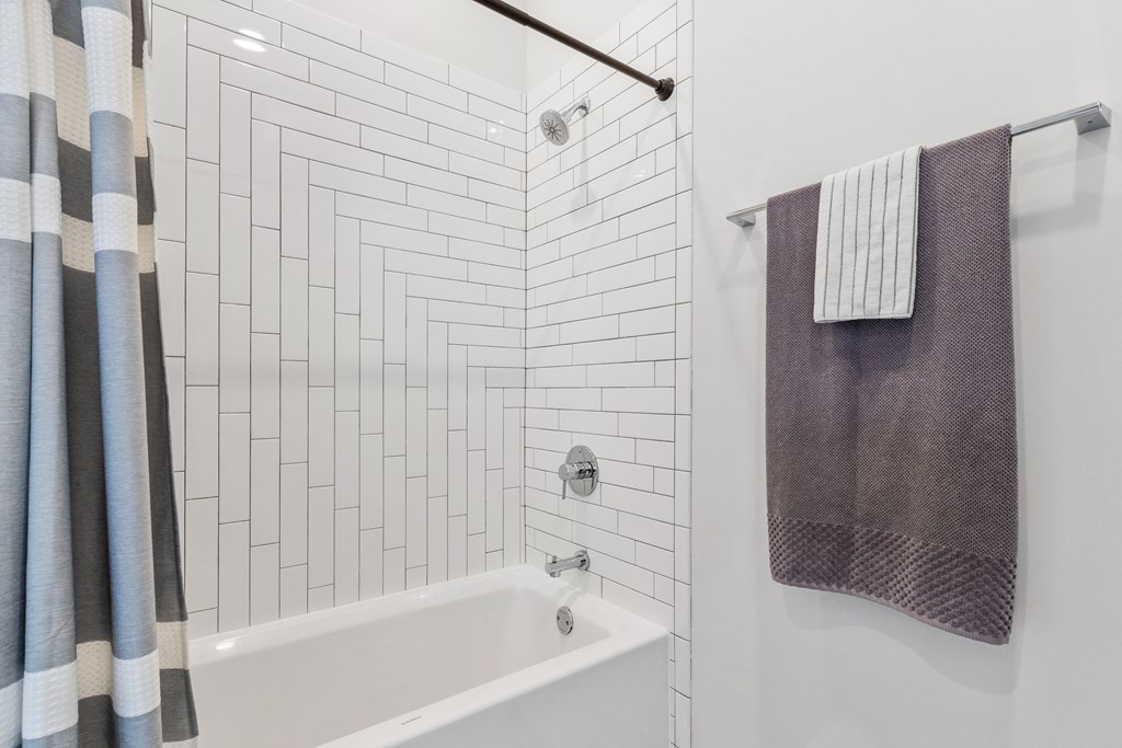 A bathroom with white European tile and a white bathtub