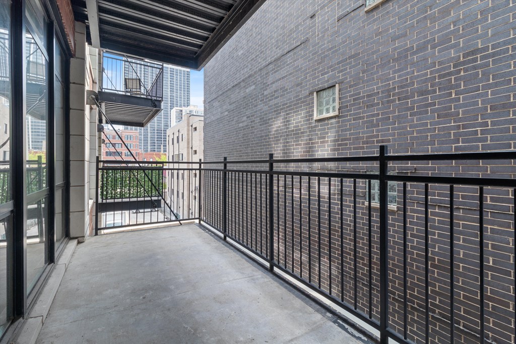 balcony with black railing and brick wall with city views at the link