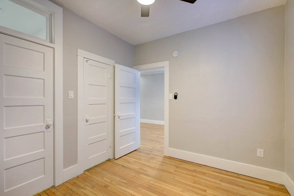 a bedroom with two closets and a door to a hallway