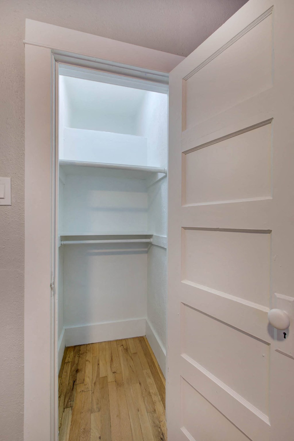 a walk in closet with shelves and a white door