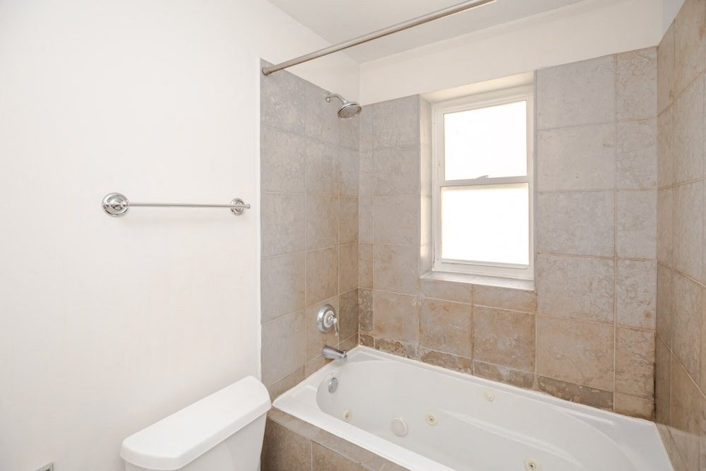 a bathroom with a tub and a sink and a window
