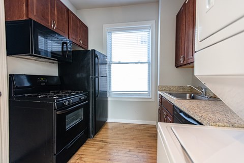 A kitchen with black appliances and wooden cabinets.
