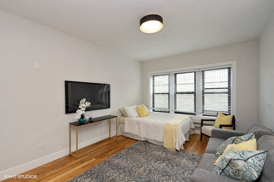 a living room with a bed and a television