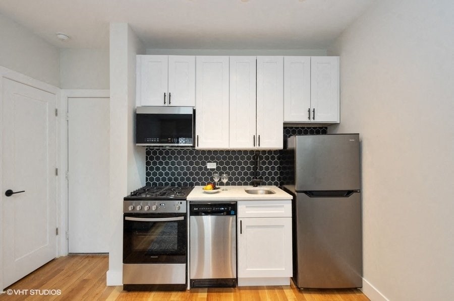 a kitchen with stainless steel appliances and white cabinets