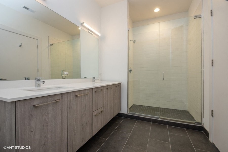 a bathroom with a shower and a sink and a mirror