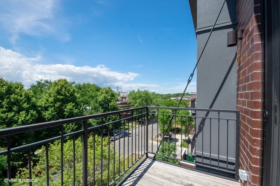 a balcony with a view of trees and a blue sky