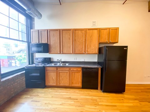 A kitchen with wooden cabinets and black appliances.