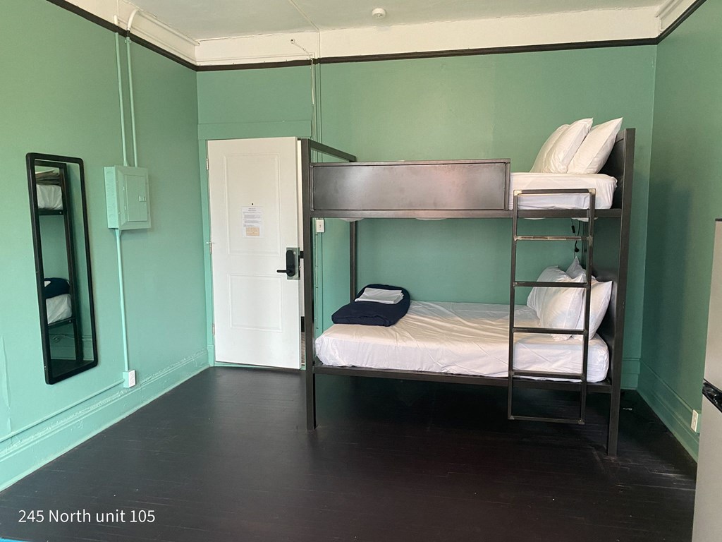 a bunk bed in a room with a mirror and a door