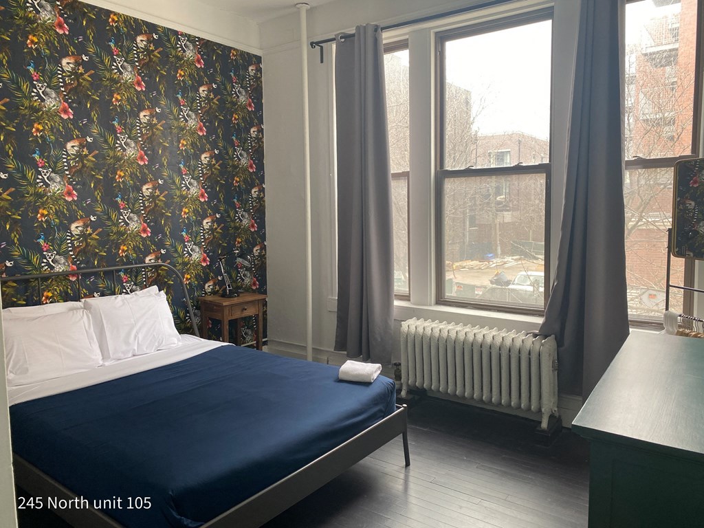 a bedroom with a bed and a radiator and a window