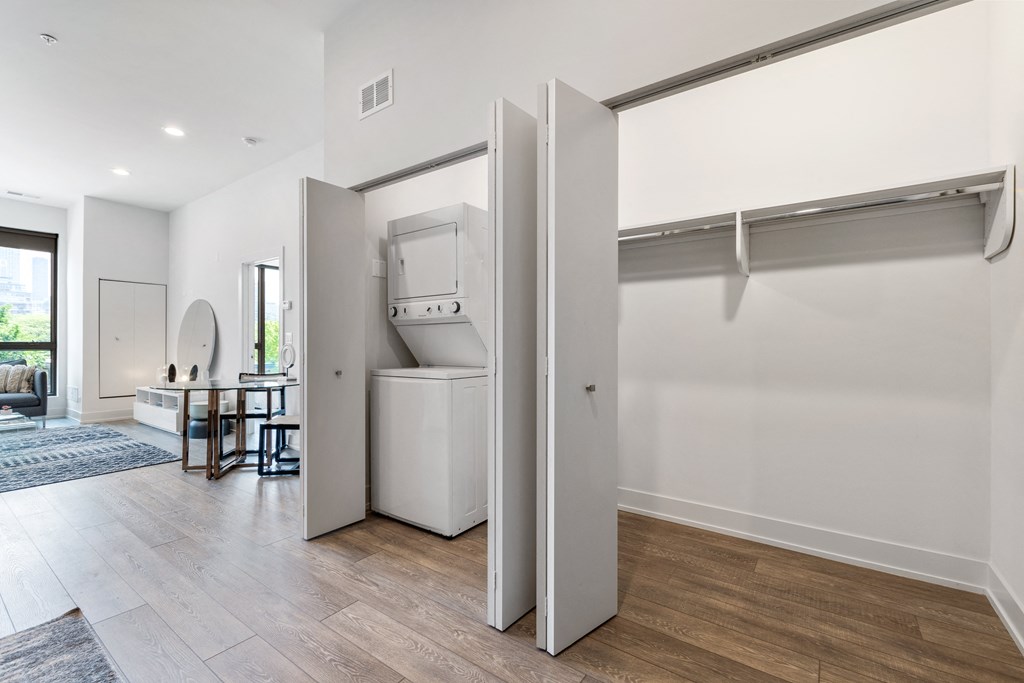 A hallway with a huge closet with a washer and dryer
