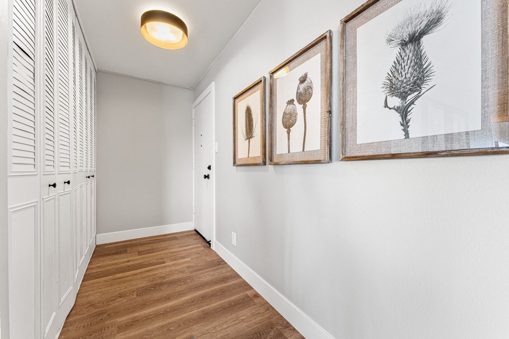 a hallway with pictures on the wall and plenty of storage