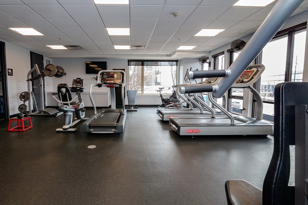 a gym with cardio machines and weights on the floor