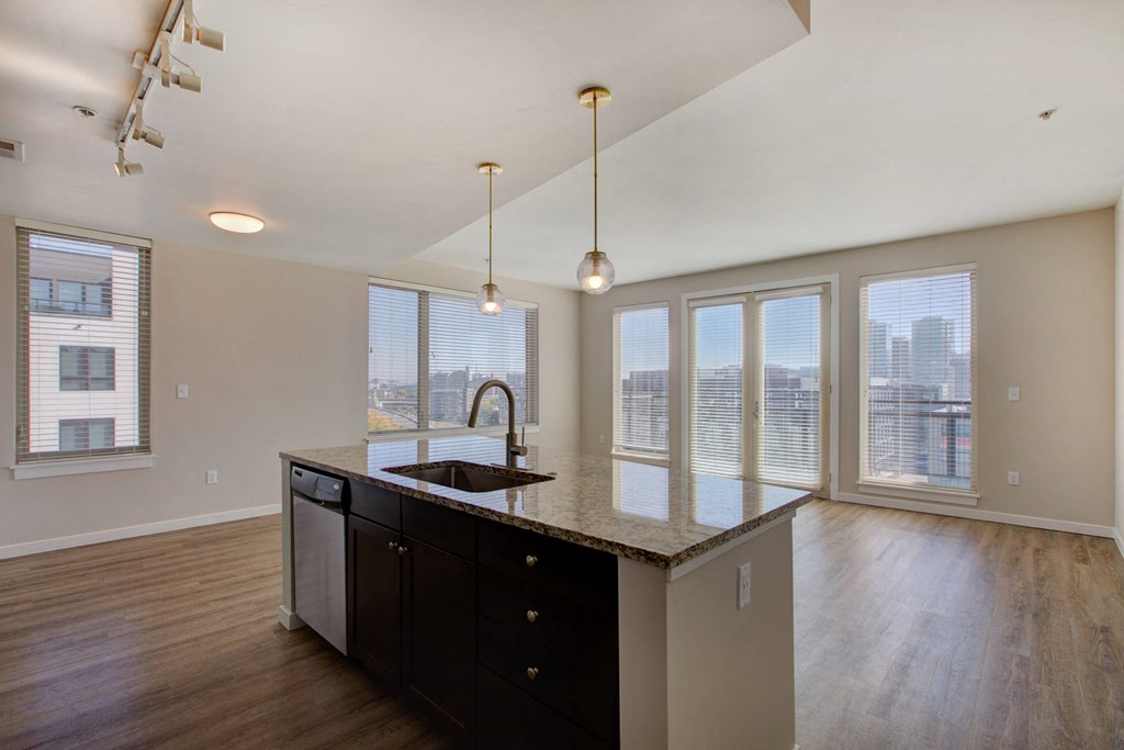 an empty kitchen with a large window and a sink