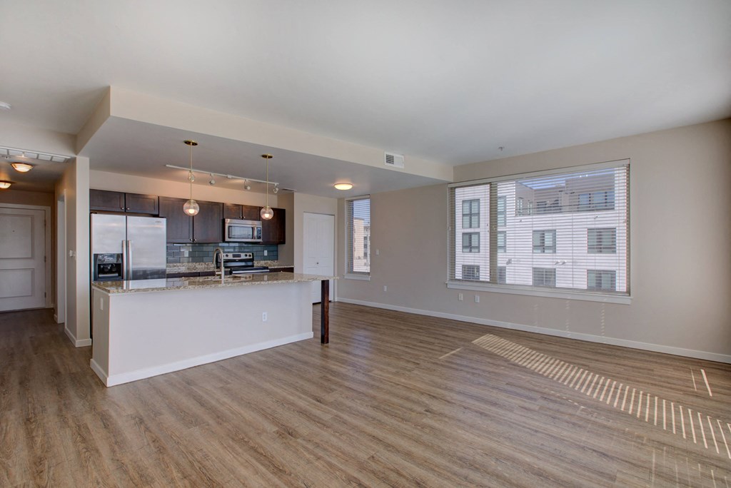 a living room with a kitchen and a large window