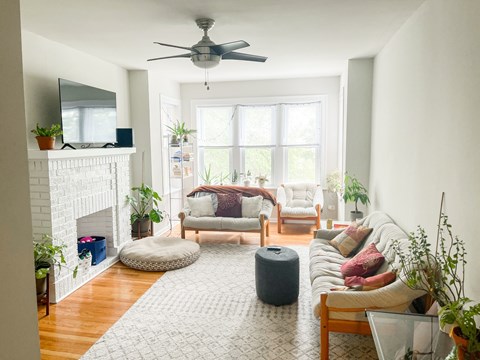 A living room with a fireplace, a couch, and a rug.