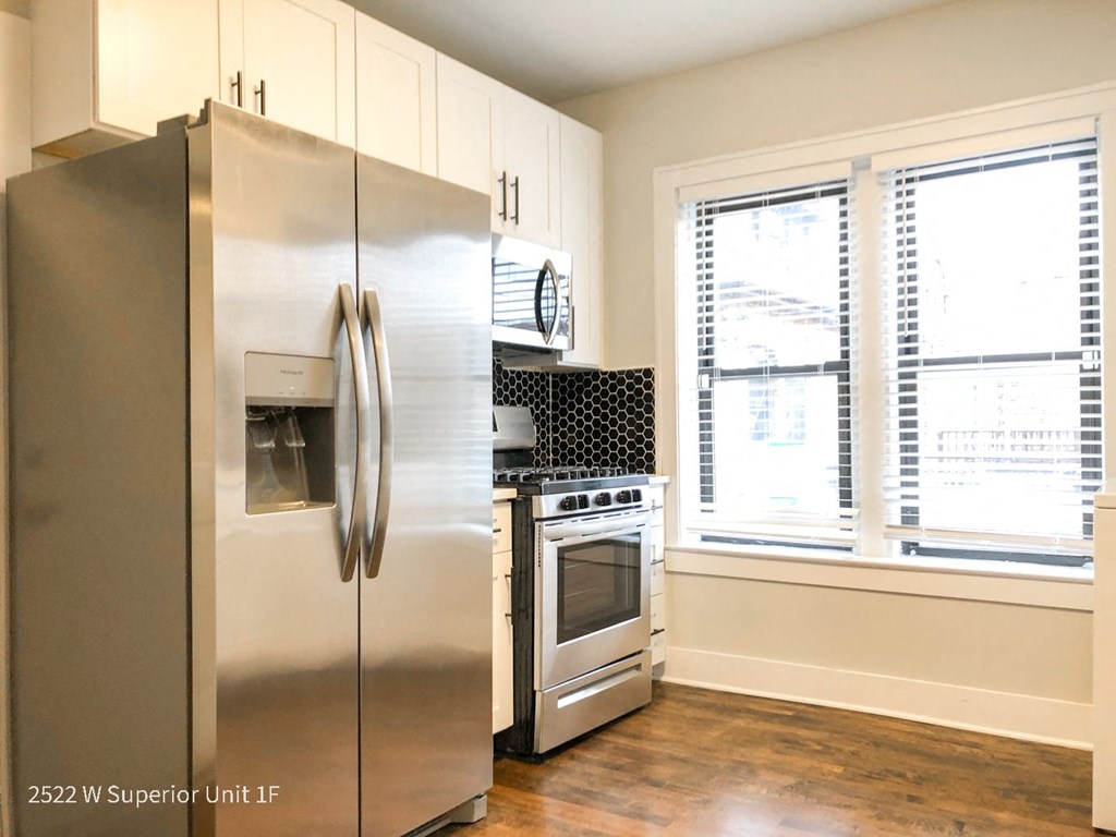 a kitchen with white cabinets and stainless steel appliances