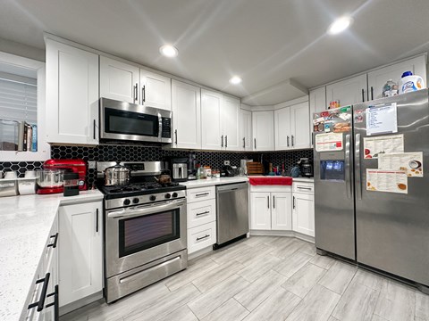 A kitchen with white cabinets and stainless steel appliances.
