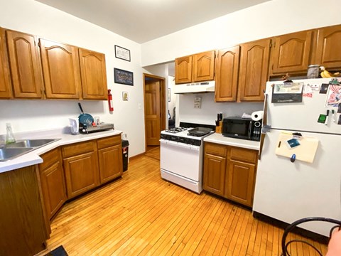 A kitchen with wooden cabinets and a white fridge.
