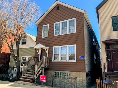 a brown house with a red sign in front of it