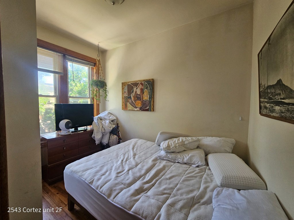 a bedroom with a bed and a dresser and a window
